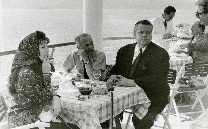 Juliette Greco, Orson Welles und Darryl Zanuck beim Mittagstisch mit Meerblick, Cannes Festival, Frankreich, 1959 | Foto: André Sartres (1911–2010, FR) | OstLicht Vintage Photo Sale